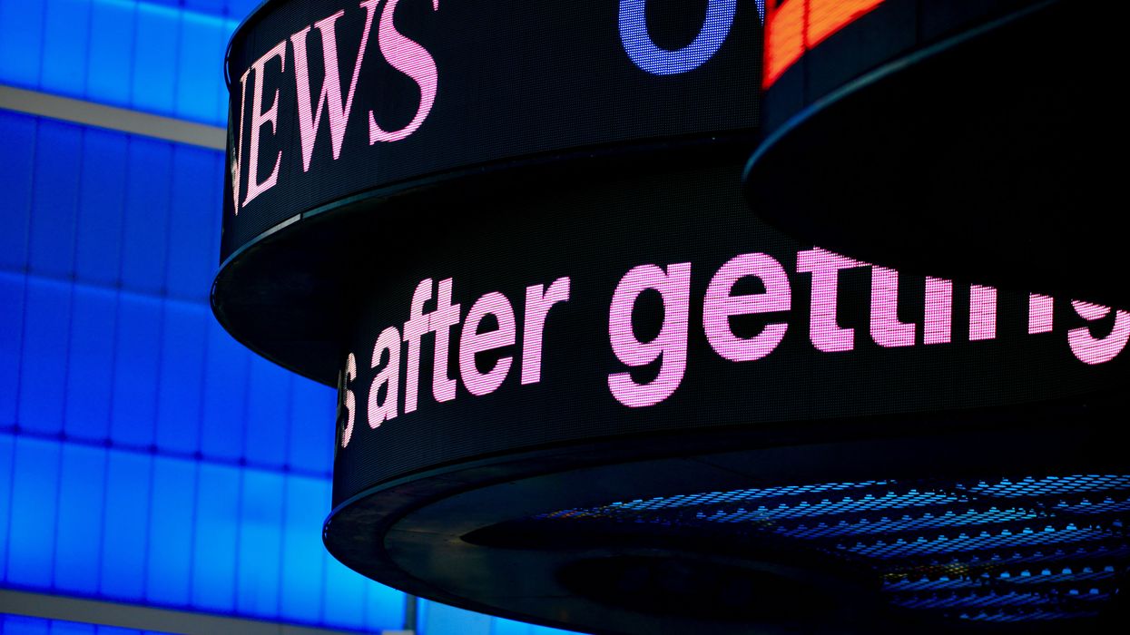 a close up of a sign with a building in the background