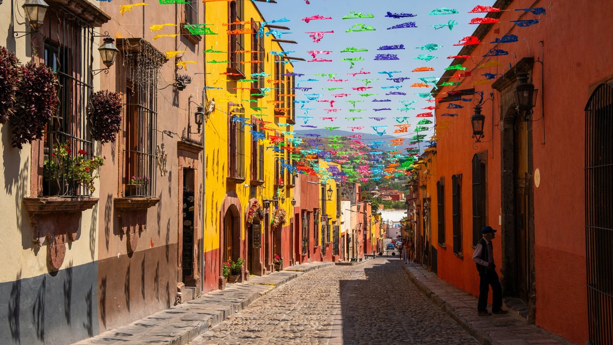 a cobblestone street in mexico lined with colorful flags