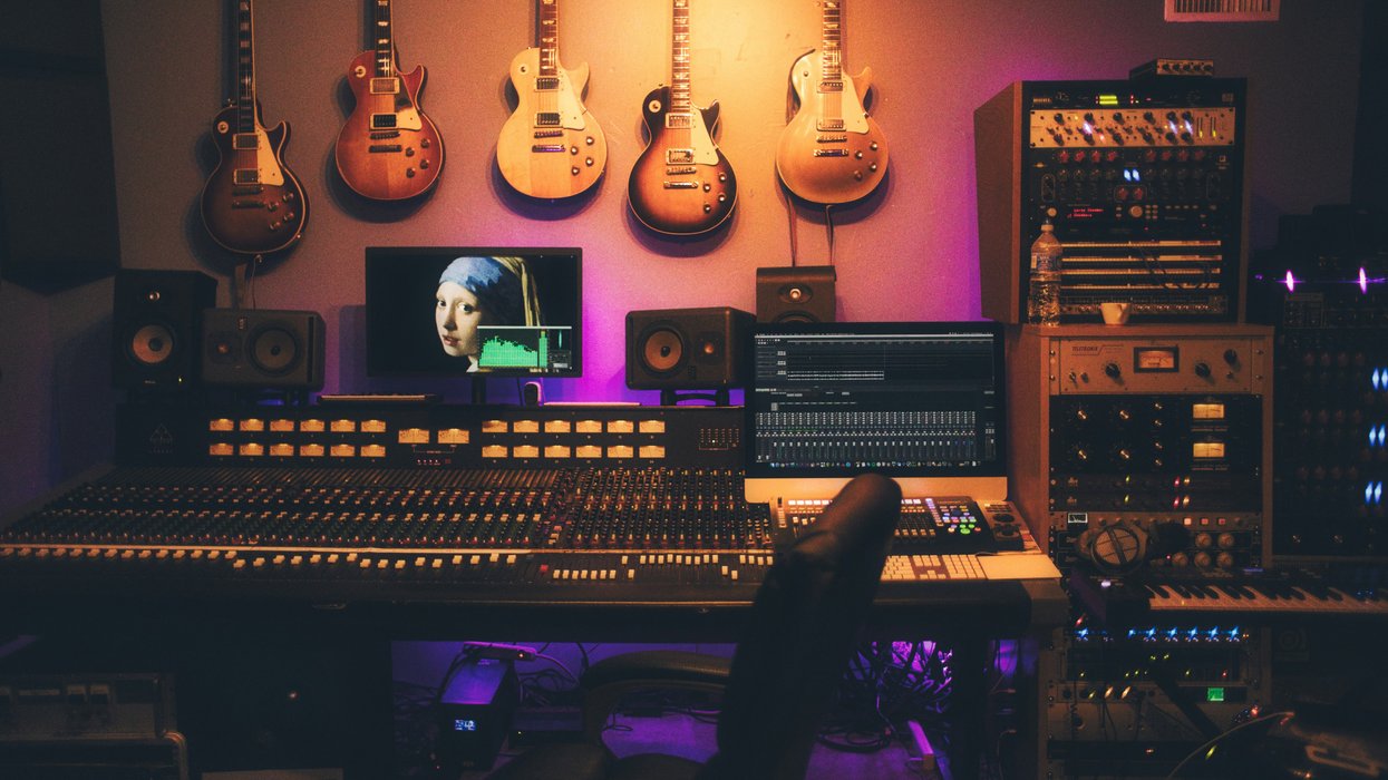 a music studio setup with brown and white acoustic guitars