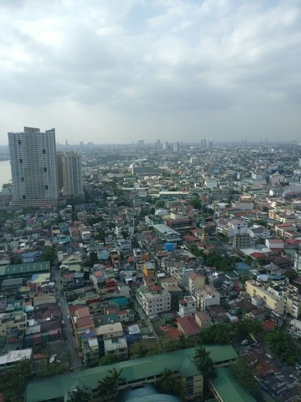 Aerial view of a densely populated urban area under cloudy skies.