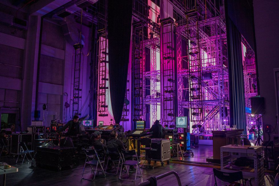 backstage at a theater with pink lighting and technical equipment setup