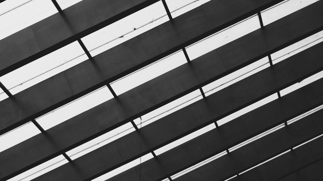 black and white view of a modern, geometric ceiling with parallel beams