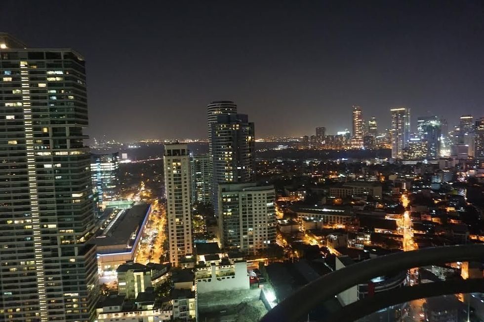 City skyline at night with illuminated skyscrapers and streets.