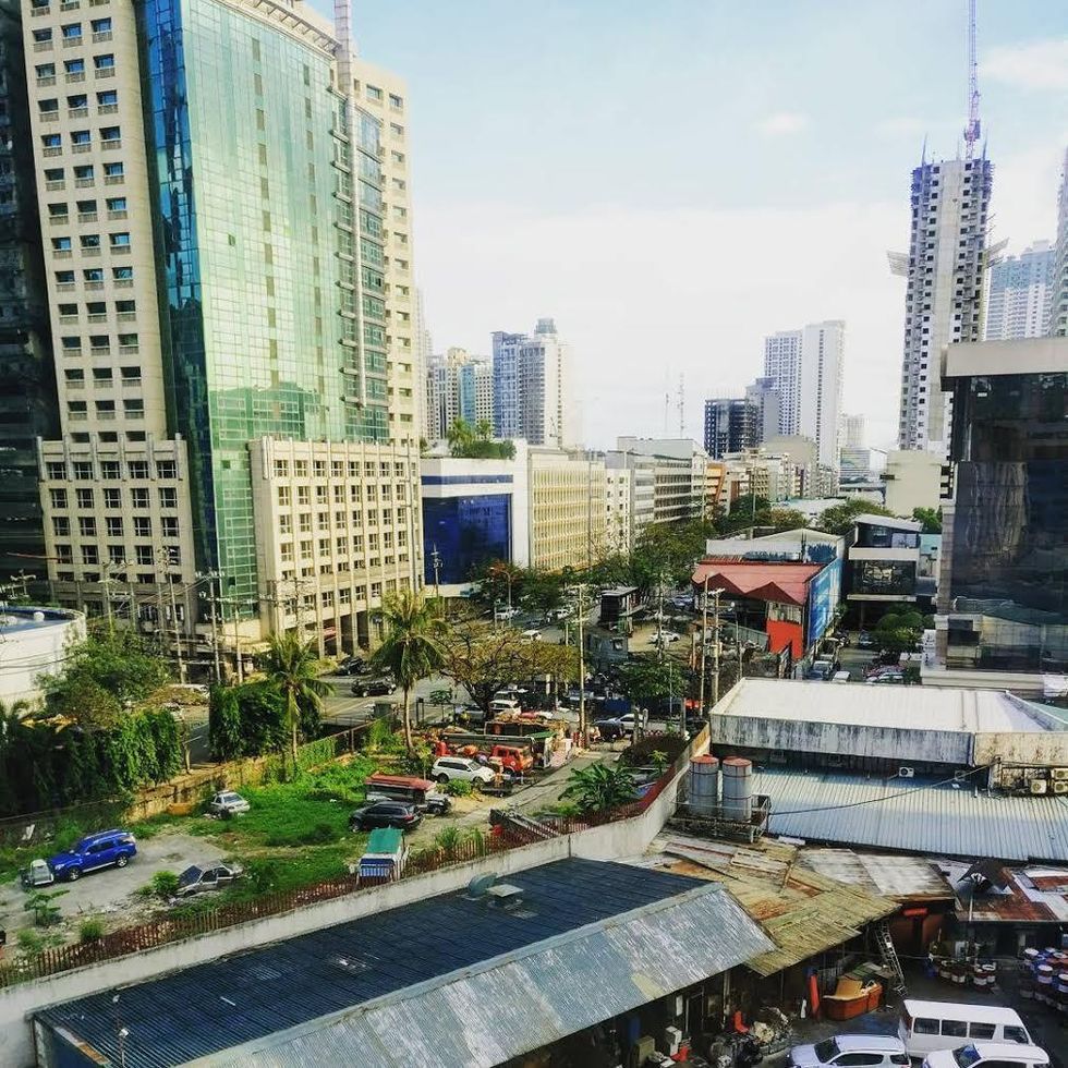 City skyline with tall buildings and busy streets under a clear blue sky.