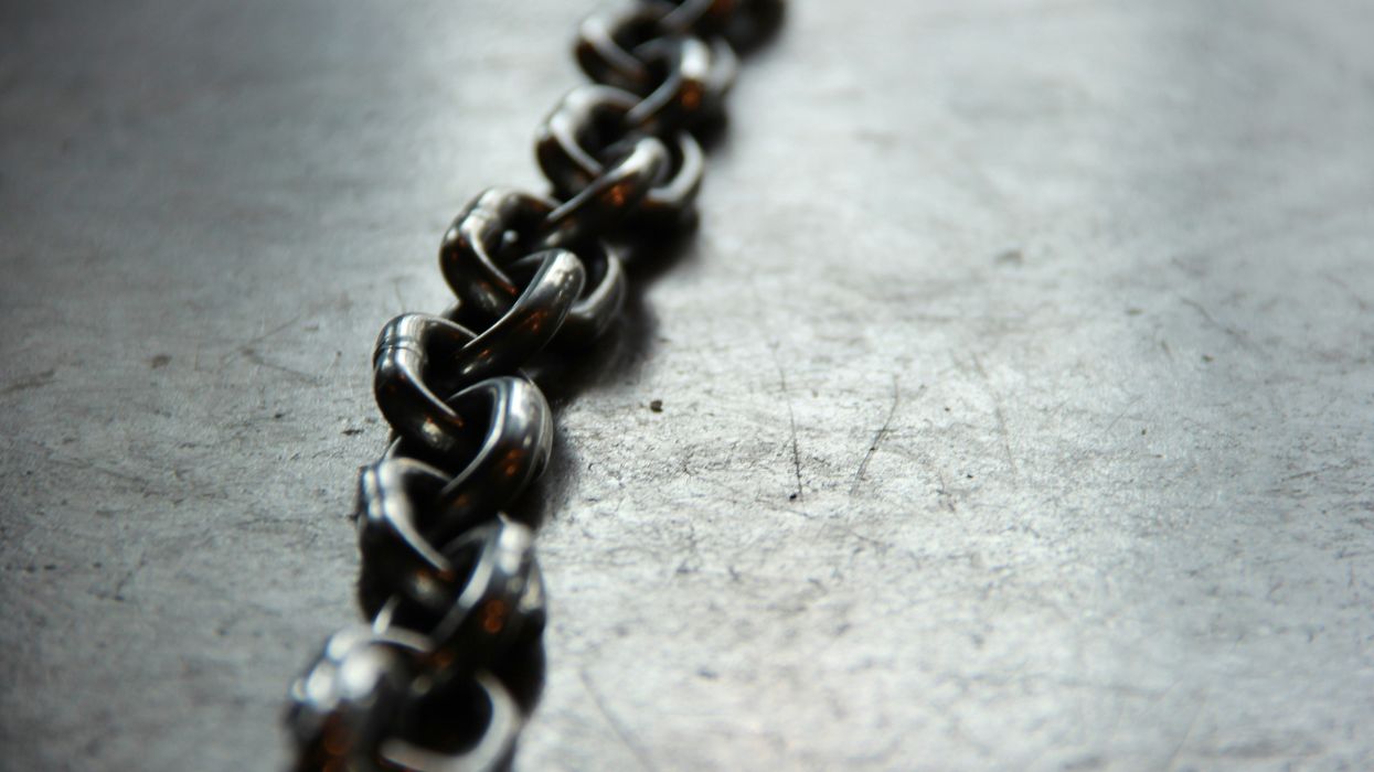 close-up view of a metal chain on a scratched, reflective surface