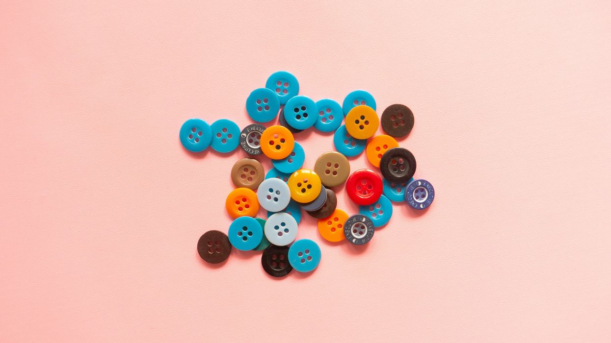 Colorful buttons scattered on a pink background.