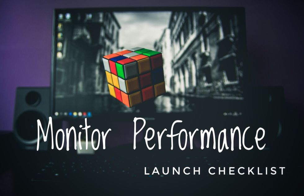 Computer screen with a Rubik's Cube, text: "Monitor Performance Launch Checklist."