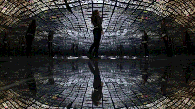 gif of someone walking on a room full of screens showing internet content