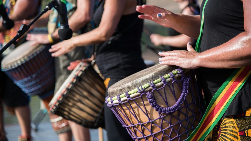 group drumming with colorful djembes and vibrant attire