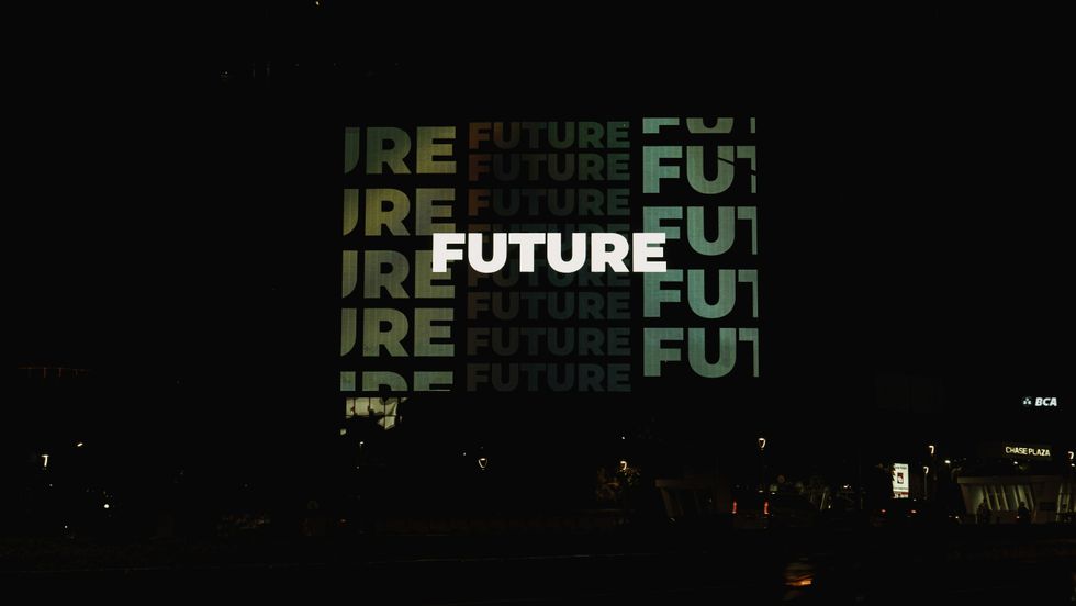 neon sign with "FUTURE" repeated on a dark building facade at night