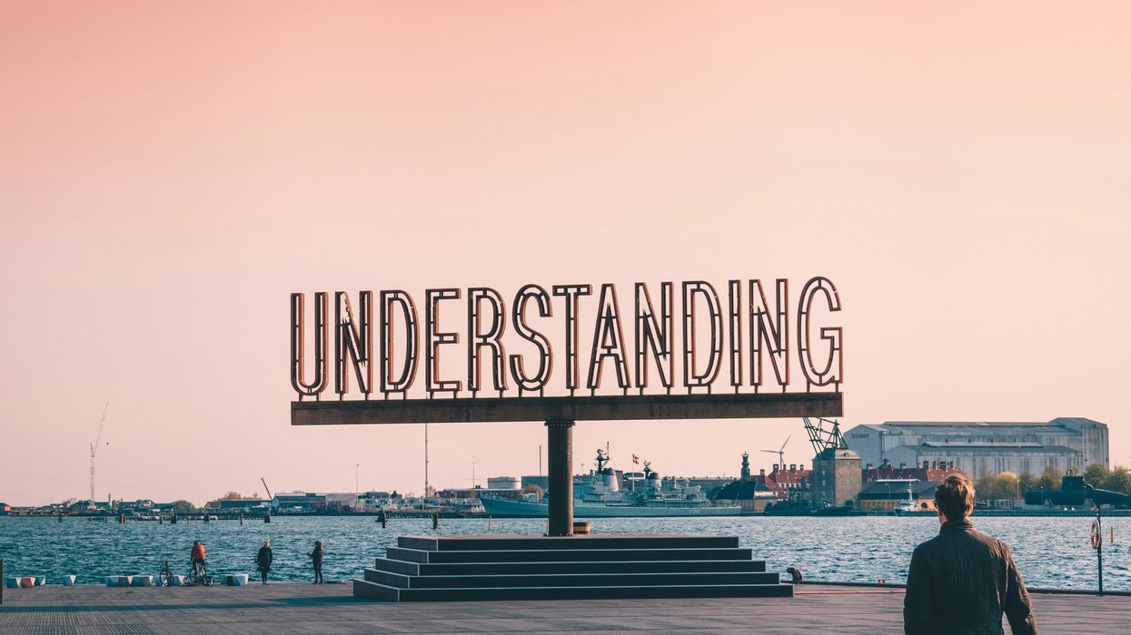 sculpture of the word "UNDERSTANDING" overlooking the water