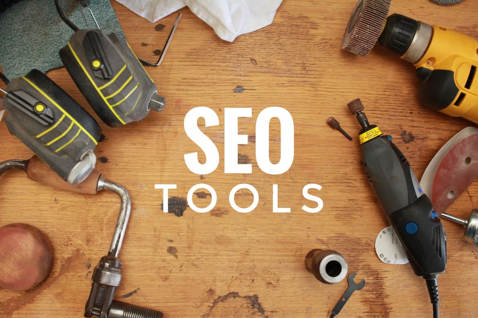"SEO Tools text with workshop tools on a wooden surface background."
