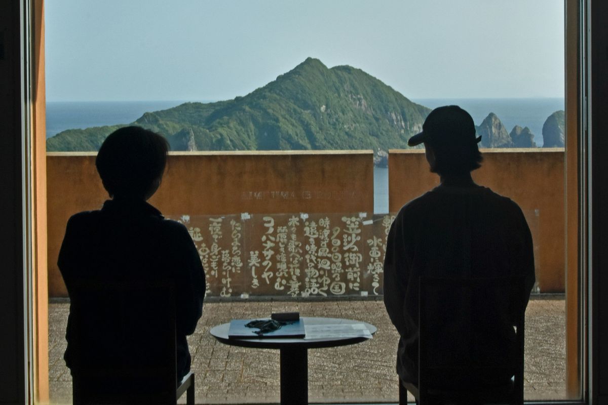 two people sitting at a table looking out a window