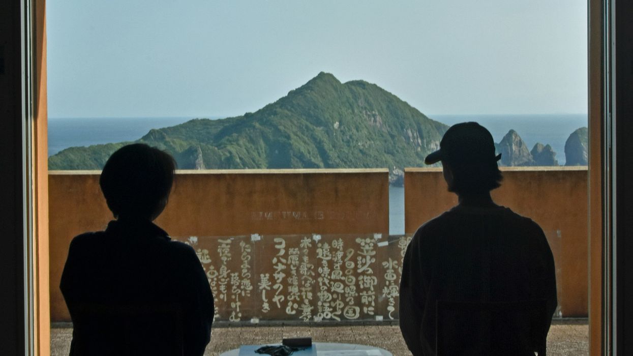 two people sitting at a table looking out a window
