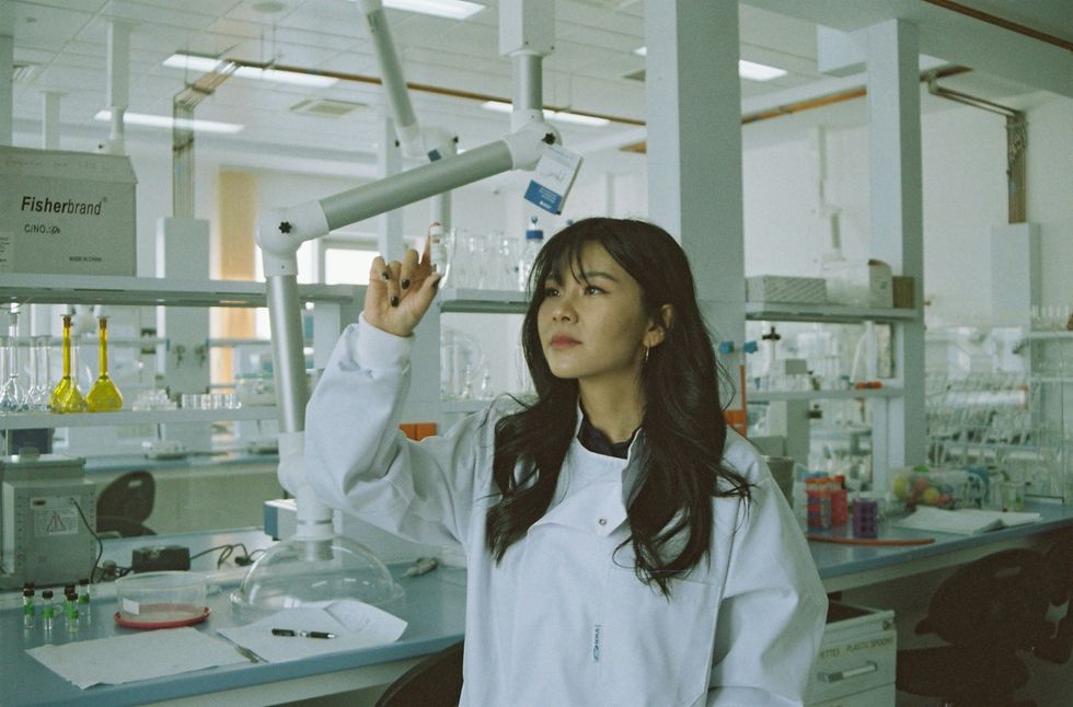 woman in lab coat inspecting a test tube in a modern laboratory setting